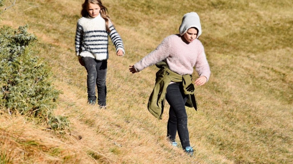 Two ladinian sisters walking slightly pissed  on the ancient pathway of Troi Pajan at Lech Dagustel in Val Gardena Gröden in Südtirol, Italy.